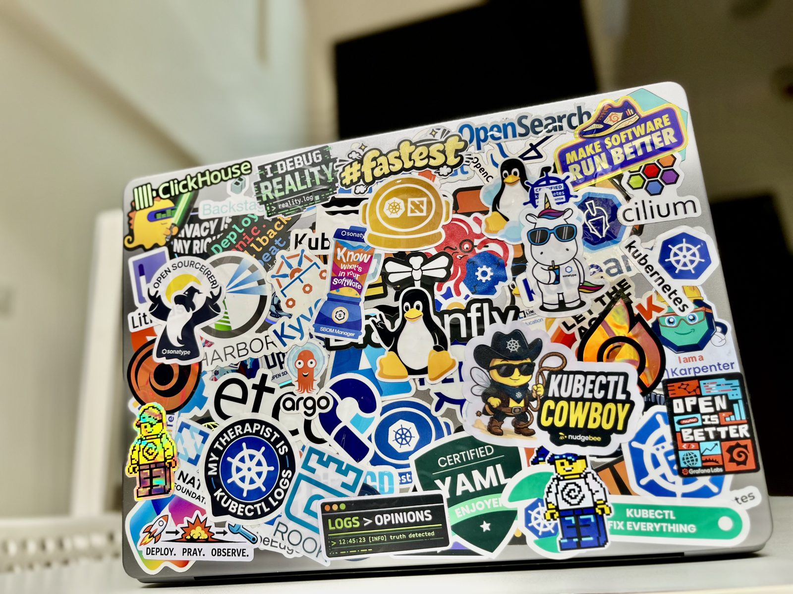 A laptop lid completely covered in cloud-native and Kubernetes stickers